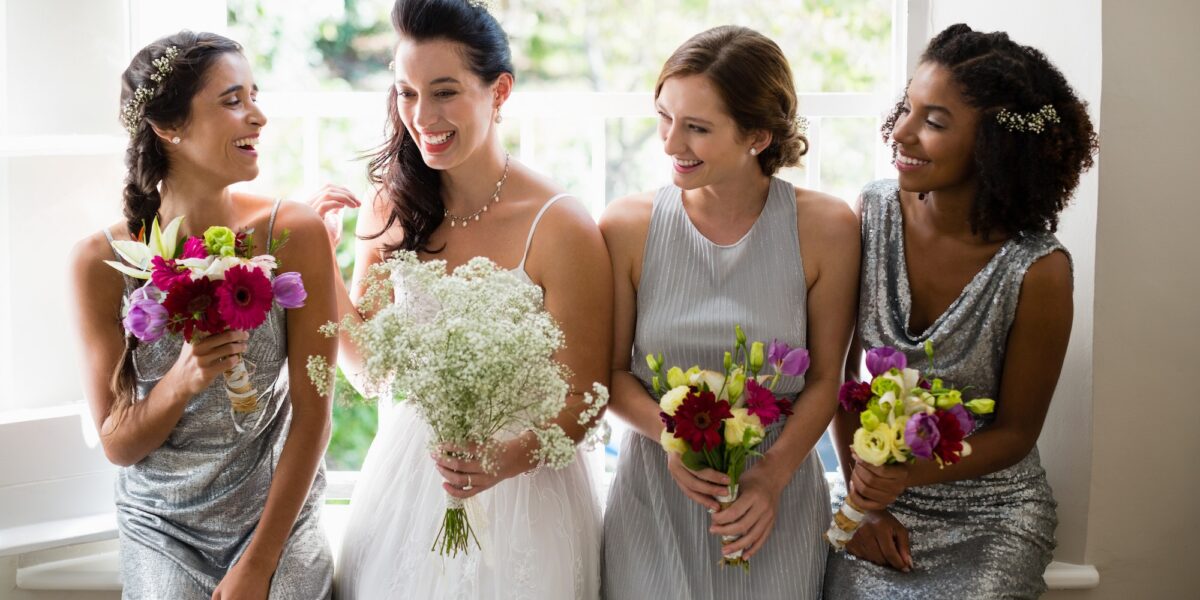 Bride and bridesmaids standing with bouquet TranscenDental Smiles provides Teeth Whitening Services