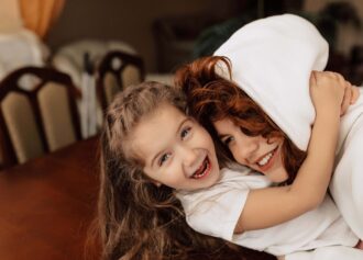 Excited happy little girl hugging mom and having fun at home Excited happy little girl hugging mom and having fun at home