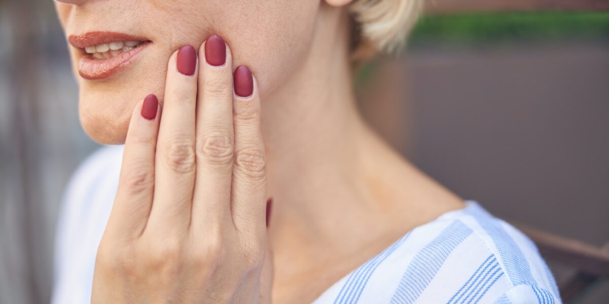 Female suffering from an acute dental pain TranscenDental Smiles is a trusted TMJ/TMD TREATMENT provider