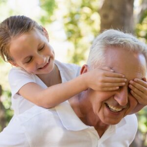 Girl covering his grandpa’s eyes in the forest Girl covering his grandpa's eyes in the forest