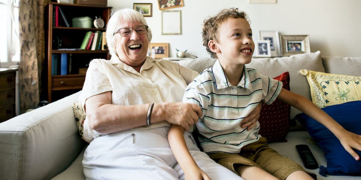 Grandma and grandson sitting on the sofa together - not an actual client with removable dentures