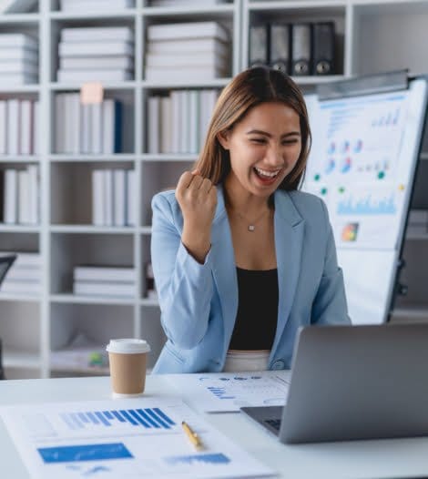 A professional woman sits at a desk with a laptop and coffee, ready to tackle her workday.