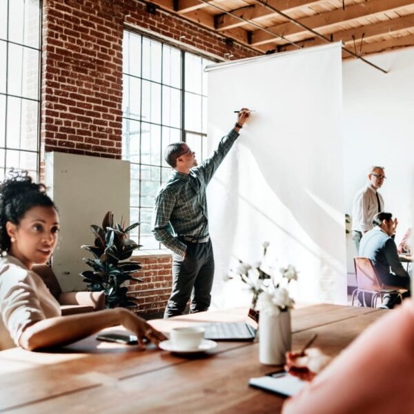 A group of people sitting at a table in an office.